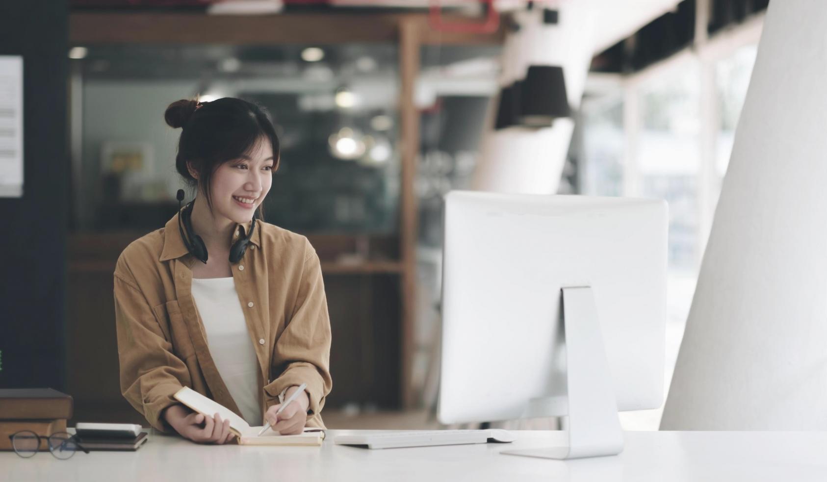 Person arbeitet konzentriert am Computer in einer modernen Lernumgebung